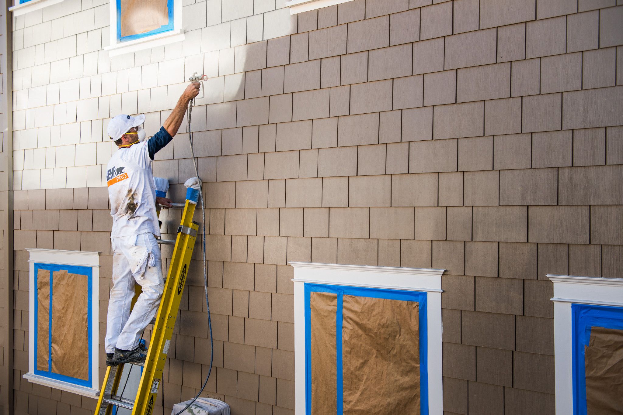 Pro painter spraying the exterior of a building