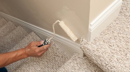 Painter Using Touch-up Roller on House Wall