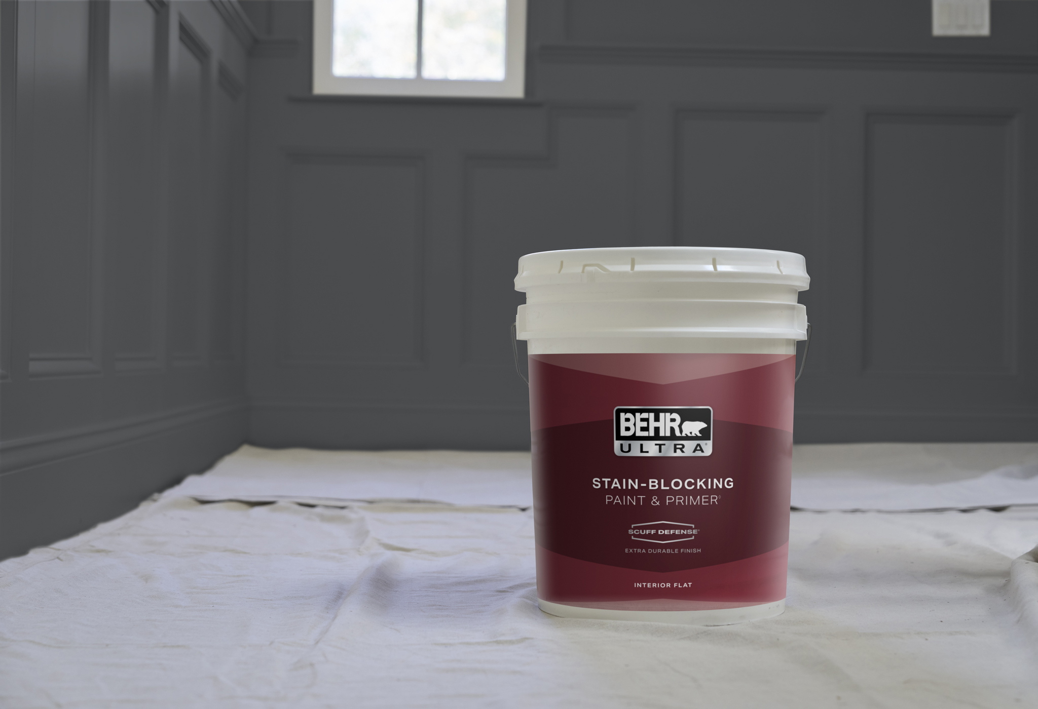 BEHR ULTRA INTERIOR PAINT 5G PRODUCT SHOT WITH RESIDENTIAL BACKGROUND THAT HAS A DARK WALL COLOR